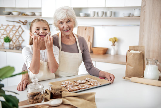 Joyful grandmother and child baking pastry together