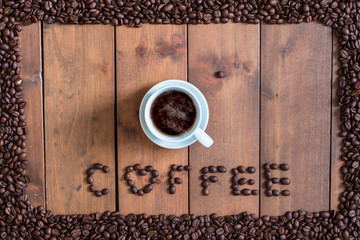 Top view cup of coffee with coffee beans square frame on wooden background.