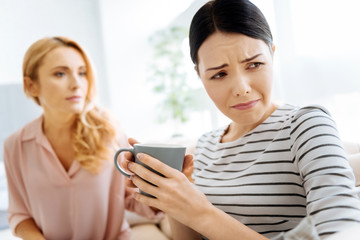Moody upset woman drinking tea