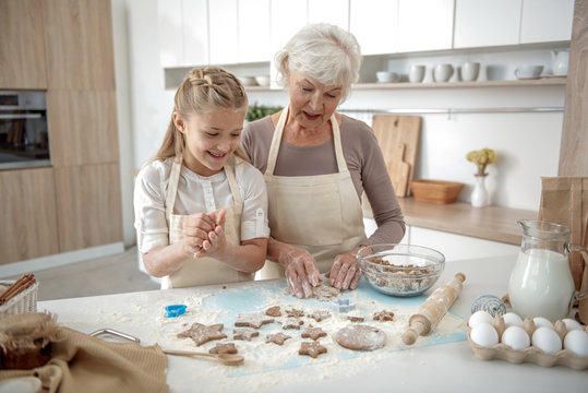 Happy girl baking sweets with her granny
