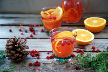 Warm cranberry drink with oranges and cinnamon. Wooden background    © Anna Puzatykh