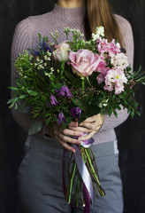 The beautiful flowers rustic bouquet in the woman hands