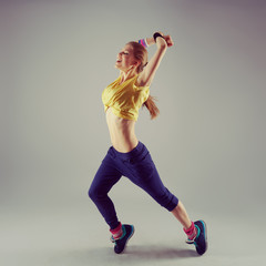 Female dancer training zumba over studio background. 