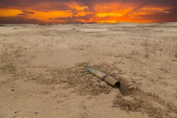 Papier Peint photo Sécheresse vieux projectile en métal d& 39 artillerie sur le sable dans le désert