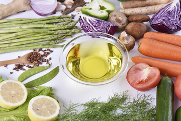 Fresh vegetables and olive oil on the white background. 