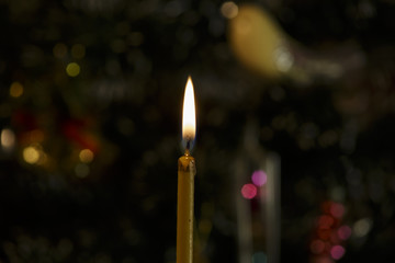 Burning Candle near Christmas Tree. Christmas Background.