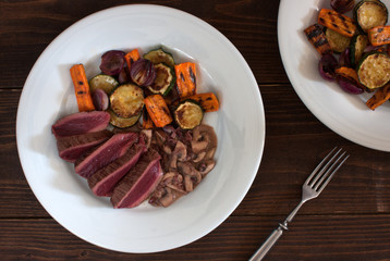 grilled rare ostrich steak with red wine and mushroom sauce and grilled vegetables