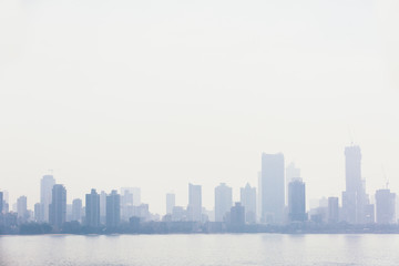 Silhouette of buildings next to the sea. Polluted skyline in Mumbai, India