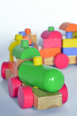 wooden train with locomotive and wagons,   assembled with colored blocks, isolated   on white background. part of a series