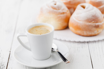 cup of black coffee and sweet bun for breakfast, close-up