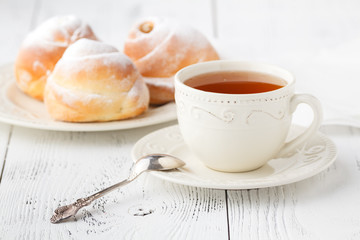 Cup of tea and small apple roses shaped pies. Sweet apple dessert pie