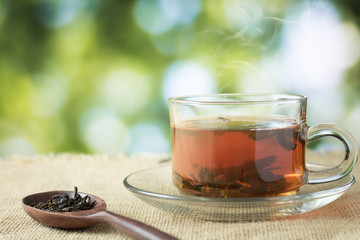 glass of hot tea on hemp sack and table in morning.