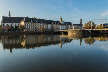 Buildings of the University Church of the Blessed Name of Jesus and the University of Wroclaw, and the University Bridge, with reflections in the Odra river at dawn, Wroclaw, Poland