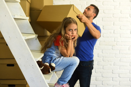 Daughter with bear sit on ladder and father puts box