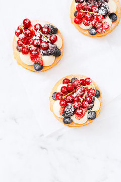 Three Berry Tarts on Marble countertop From above