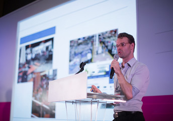 Man Presenting on Stage. Holding Microphone