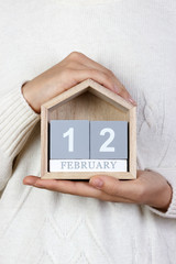 February 12 in the calendar. the girl is holding a wooden calendar. International Day of Marriage...