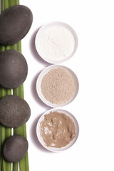 White and green cosmetic clay beside zen stones
