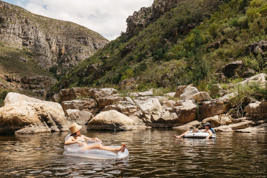 Couple relaxing on inflatable lilo's in a river or dam