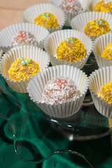 Yellow and white cakes in white cups on a glass stand