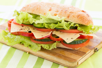Ciabatta Sandwich with cheese on cutting board
