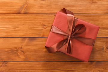 Present in gift box on wood background with copy space