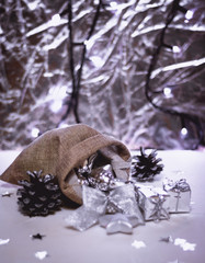 Beautiful silver Christmas decorations spilling out of a hessian sack