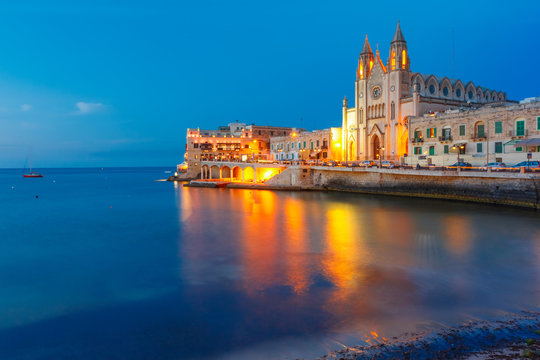 Balluta Bay and Neo-Gothic Church of Our Lady of Mount Carmel, Balluta parish church, during evening blue hour, Saint Julien, Malta
