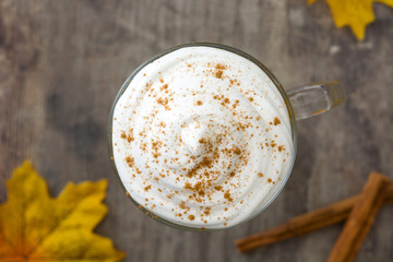 Pumpkin spiced latte on wooden table.Top view
