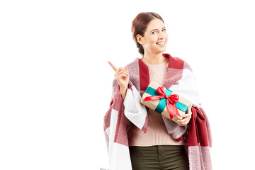 Portrait of woman wrapped in blanket holding Christmas gift