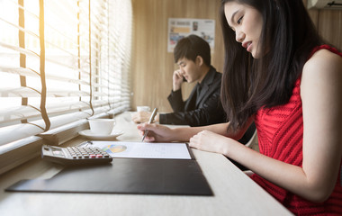 Young beautiful woman working business marketing chart and Young man talking smart phone at workplace office
