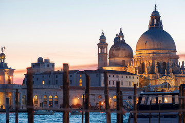Fototapeta na wymiar Gondolas moored by Saint Mark square with Cathedral of Santa Maria della Salute on background
