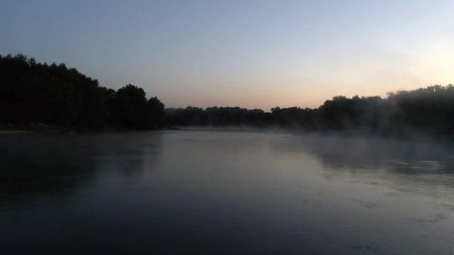 Aerial photography of the river at dawn. Rising mist from the river against the background of the rising sun