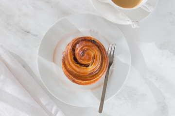 French pastries. fresh scones of snail with custard and raisins on a white background. view from above.