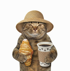 The cat in a straw hat is holding a cup of black coffee and a croissant. White background.