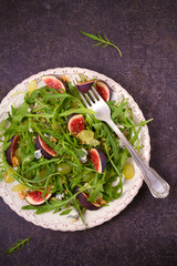 Grapes, figs, blue cheese, arugula and walnuts salad. View from above, top studio shot, vertical