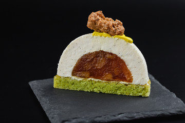 Cut vanilla mousse pastry dessert with caramelized pear