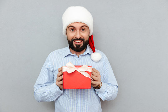 Surprised happy Bearded man in business clothes and christmas hat