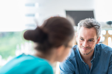 Two colleagues discussing at the office, focus on the man