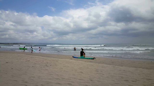 Wave surfers at the sea of Kuta beach, Bali