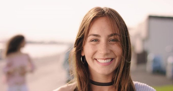 Young brown haired woman laughing with friends in the background