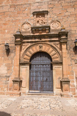Fototapeta na wymiar landmark of ornate ancient door and facade of church San Mateo, gothic and renaissance from Fifteenth century, in Banos de la Encina, Jaen, Andalusia, Spain Europe 