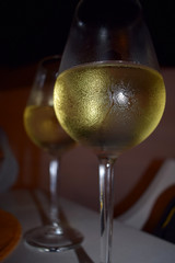 Two glasses of cool white wine on a table 