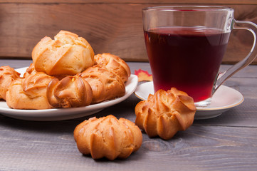 Fresh fragrant delicious cookies on a white plate with fruit tea on the background of a table made from old wood