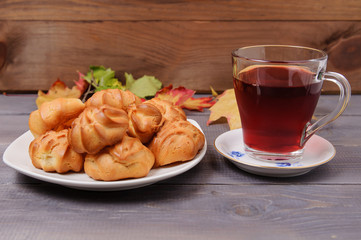 Fresh fragrant delicious cookies on a white plate with fruit tea on the background of a table made from old wood