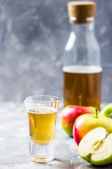 Detox apple cider drink in a bottle and fresh apples on stone background. Selective focus, space for text. 
