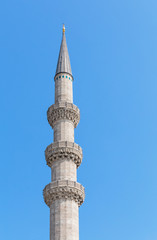 Fototapeta na wymiar One white minaret on blue sky background