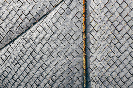 Chainlink fence in front of silver tarp