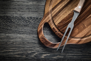Meat fork chopping board on wood background