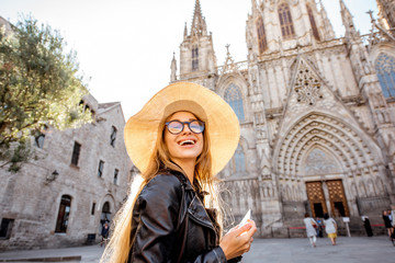 Young woman tourist standing in front of the famous saint Eulalia church during the morning light in Barcelona city
